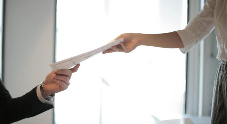 job applicant passing her documents